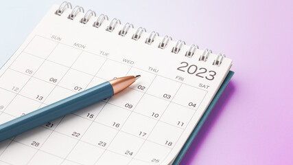 Calendar 2023 with blue pen on pink gradient background