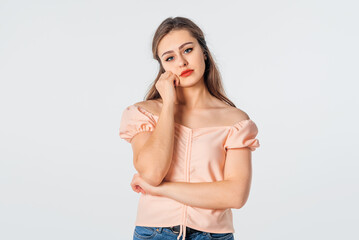 Fototapeta premium Bored and lazy people. Young brunette woman wearing casual clothes, thinking, looking tired and bored with depression problems, standing over white background