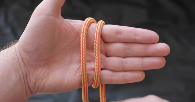 Tying an Alpine butterfly mountaineering knot loop used in climbing, glacier travel, sailing. POV, hands, how to tie.