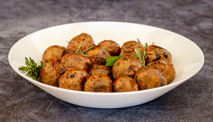 Fried (baked) whole small potatoes with rosemary and salt in a frying pan, ruddy crust, appetizing food