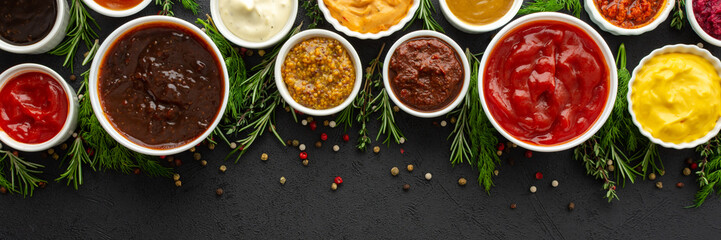 Different types of sauces in bowls with seasonings banner, rosemary and dill, thyme and and peppercorns, top view, copy space