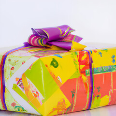 Birthday gift wrapped in colorful paper tied with pretty ribbon and bow