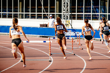 women running 400 - meter hurdles in athletics competition