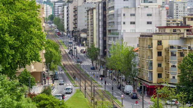 Traffic and metro line on the busy street near Jardim do Morro in Vila Nova de Gaia and Porto cityscape aerial timelapse with in Portugal, historic city centre from above