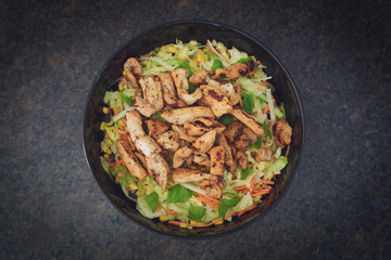 sliced and grilled chicken fillet with green salad, corn and carrots