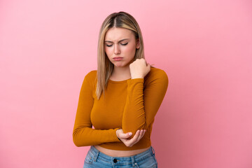 Young caucasian woman isolated on pink background with pain in elbow