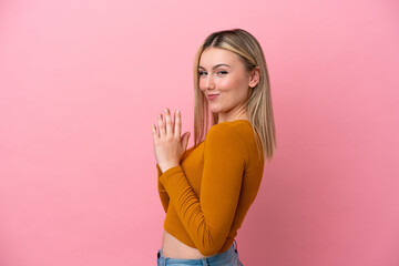 Young caucasian woman isolated on pink background scheming something