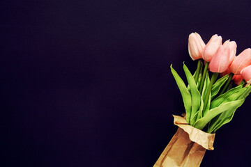 fresh tulip flowers on a dark background, space for text or advertising