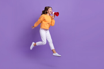 Full body profile photo of overjoyed girl jumping hold loudspeaker empty space isolated on violet...
