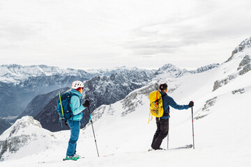 Caucasian couple of mountaineers ski touring up in the snowy Alps