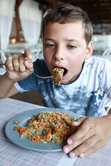 Hungry child eating pilaf
