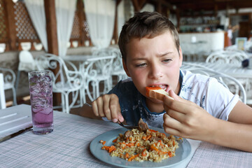 Hungry kid eating pilaf