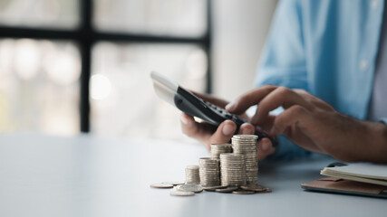 Person with stack of coins, saving money concept for future use and financial stability, savings for housing, payroll management, personal finance, investment savings.
