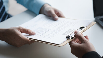 A person attends a job interview with a manager to join a company, he holds a resume and interview with information introducing himself and his ability to work. Job application concept.