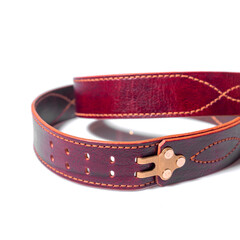 A rolled-up brown leather belt with a metal buckle on a white background is isolated.