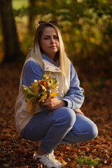 Photo of charming positive lady toothy smile arms hold collect golden fallen leaves free time outside