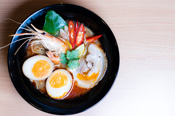 Tom Yum Ramen topped with chashu pork, soy sauce pickled eggs, river prawns and tom yum spices. Tom Yum Ramen is a Japanese-style noodle that fuses with Thai Tom Yum to give it a savory flavor.