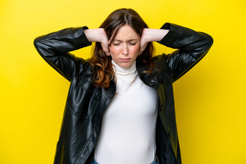 Young caucasian woman isolated on yellow background frustrated and covering ears