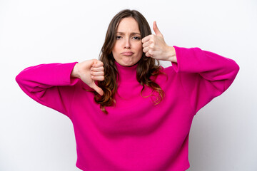 Fototapeta premium Young caucasian woman isolated on white background making good-bad sign. Undecided between yes or not