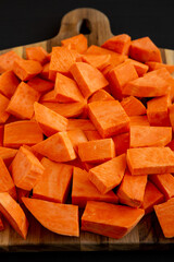 Raw Chopped Sweet Potatoes on a Cutting Board, low angle view.