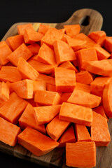 Raw Chopped Sweet Potatoes on a Cutting Board, low angle view.
