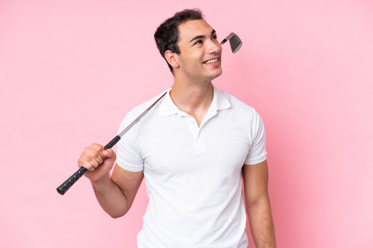 Young golfer player man isolated on pink background thinking an idea while looking up
