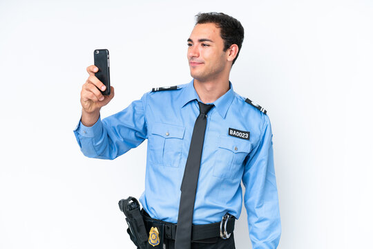 Young police caucasian man isolated on white background making a selfie