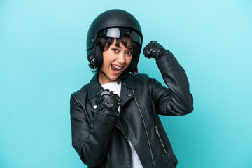 Young Argentinian woman with a motorcycle helmet isolated on blue background celebrating a victory - obrazy, fototapety, plakaty