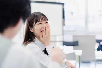 同級生と教室で仲良く話す高校生