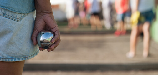 Senior playing petanque un and relaxing game. Senior woman prepared to throw the boules ball in a...