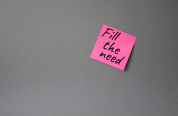 Fill the need symbol. Concept word Fill the need on steaky pink note. Beautiful grey background. Business and Fill the need concept. Copy space