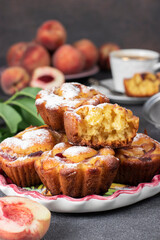 Homemade muffins with peaches sprinkled powdered sugar on plate on brown background, Close-up