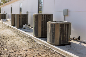 An outdoor air conditioning unit has been installed on house exterior concrete foundation in order to provide cooling