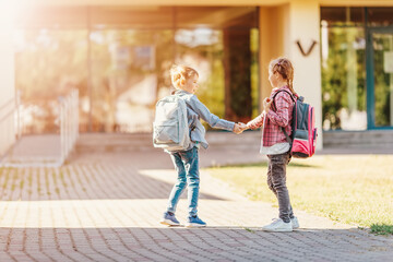 Girl and boy standing near the school together.
