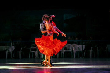 couple dancers dancing in dark gym in spotlight