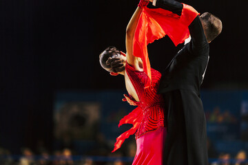 dancers man in black tailcoat and woman in red ball gown
