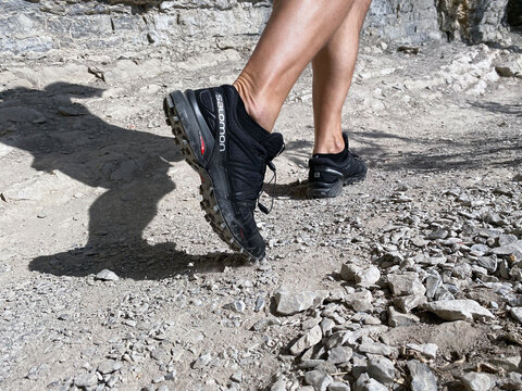 Sochi, Russia - October 6, 2020: legs man in running shoes Salomon Speedcross 4 gtx hiking on mountain trail