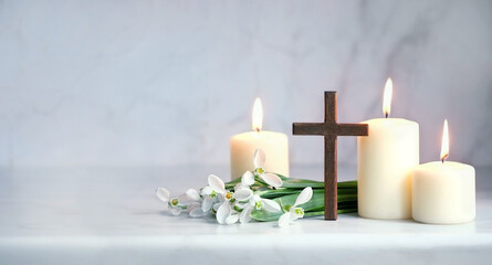 Wooden cross, snowdrops flowers and candles on table, blurred abstract background. Religious church holiday. symbol of faith in God, Christianity Feast, Easter, Palm Sunday, Lent - Powered by Adobe