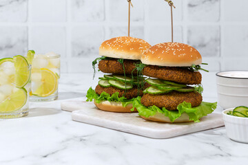 vegan lentil burgers with cucumber and salad on white kitchen table