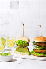 vegan lentil burgers with cucumber and salad on white kitchen table