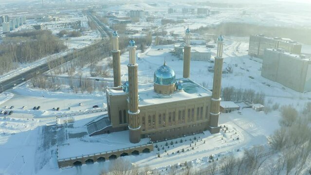 mosque building on the background of the city and the park in winter, a beautiful sunset and soft light. Ust Kamenogorsk Kazakhstan.