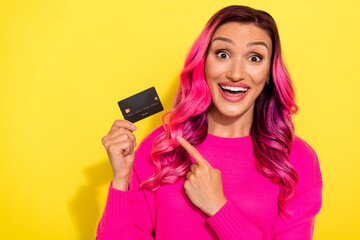 Naklejka premium Photo of surprised youngster lady pointing debit card receive bank vip card isolated on yellow color background
