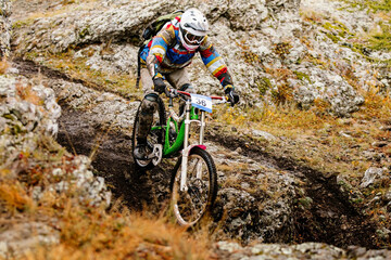 dirty rider riding on autumn trail in downhill race