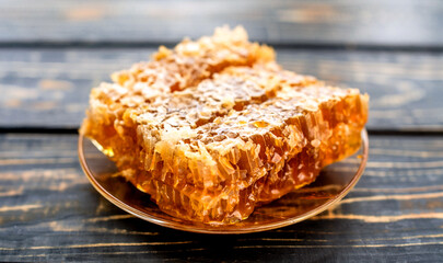 honey in honeycombs on a brown wooden background
