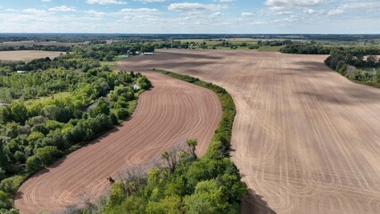 Vast farmland with corn fields beside Lake Ontario in up state New York under blue sky and clouds © Steve