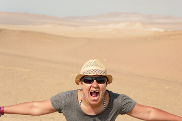 Latino woman with open arms and euphoric gesture in the desert 