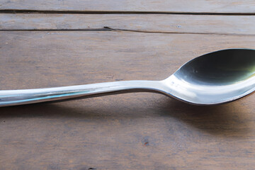 Silver spoon on old wooden table top