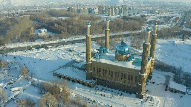mosque building on the background of the city and the park in winter, a beautiful sunset and soft light. Ust Kamenogorsk Kazakhstan.