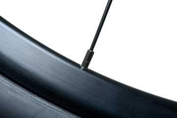 Close up of a new clean bicycle wheel rim and spoke with a transparent background. Shows a single spoke and a black colored rim.
