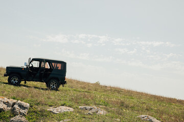 atomobil jeepy stands on a mountain in nature on a field